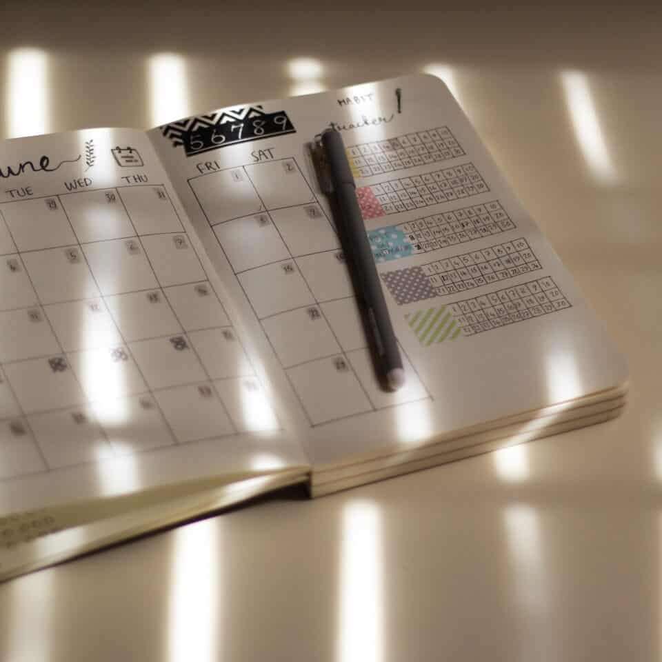 White Calendar On Brown Wooden Table